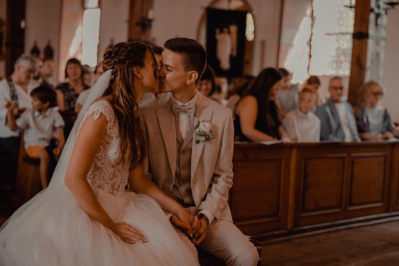 Brautpaar von Fotograf beim Kuss in der Kirche